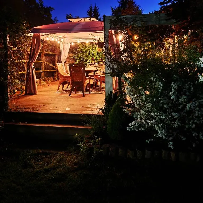 Taras pod altaną wieczorem, oświetlony girlandą lampek